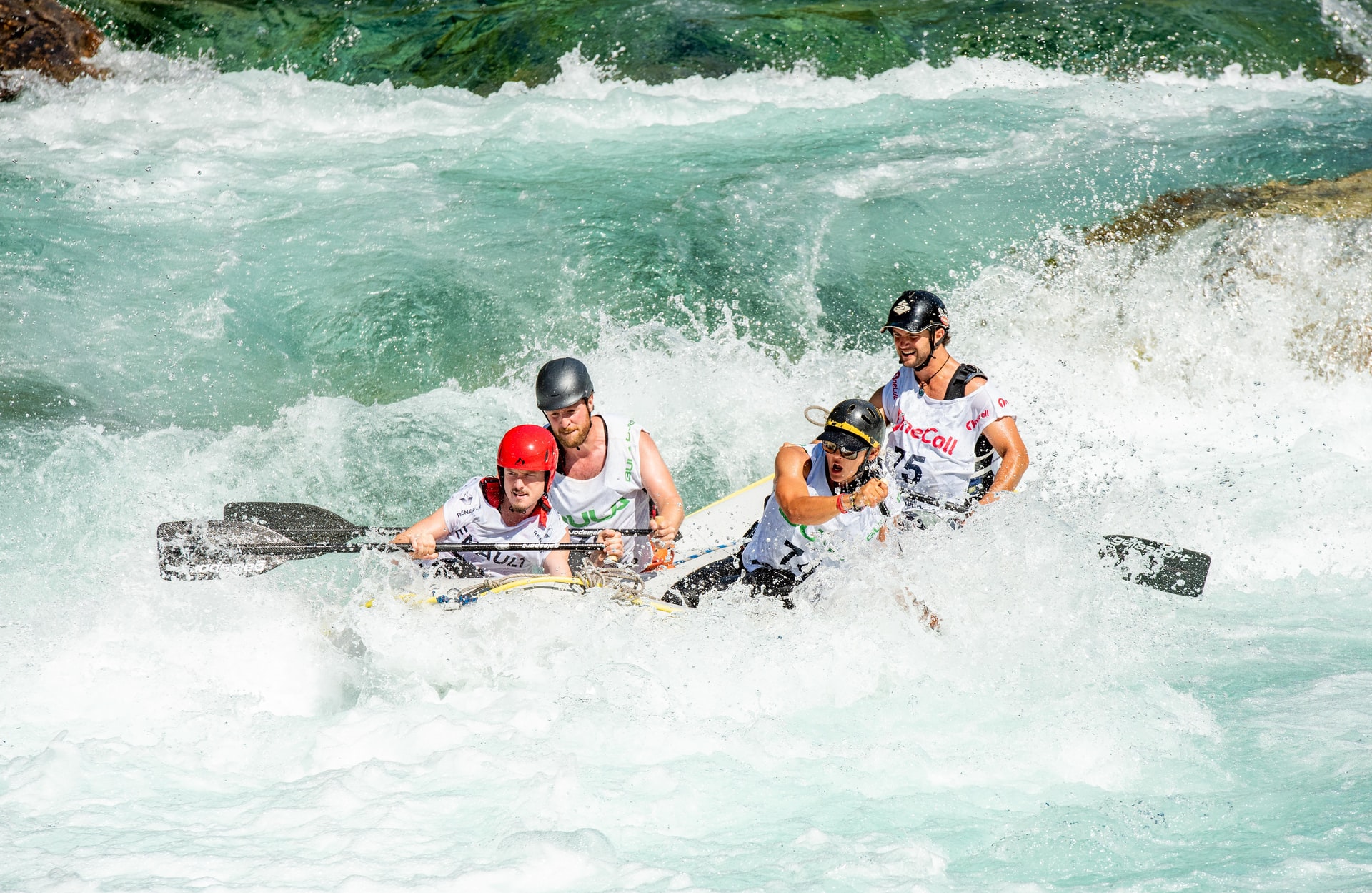 People rafting down a river rapid.
